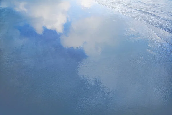 Dalgalar kumsalda bulutlarda yansıması — Stok fotoğraf