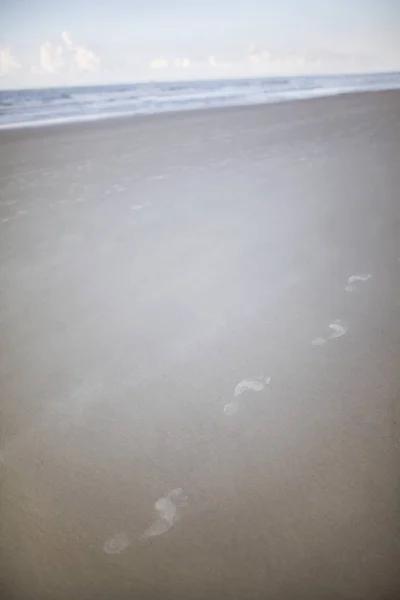 Fotspår i sanden på stranden — Stockfoto