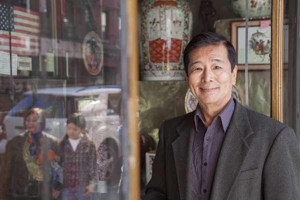 Asian man in front of store