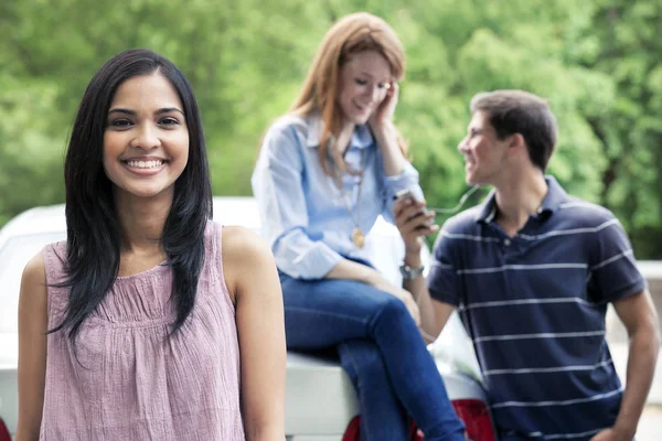 Tonåringar använder mobiltelefon nära bil — Stockfoto