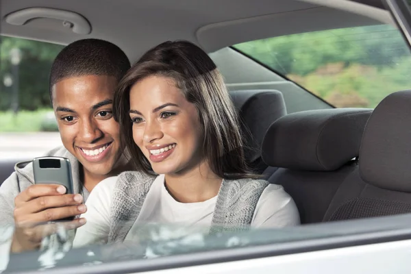 Teenagers using mobile phone in car — Stock Photo, Image