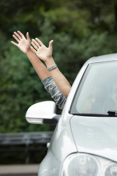 Hands sticking out of car — Stock Photo, Image