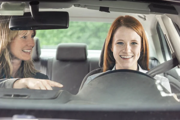 Teenager i bil med køreinstruktør - Stock-foto