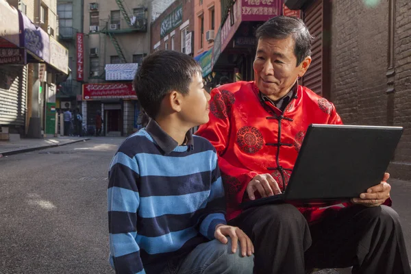 Дедушка и внук используют ноутбук Лицензионные Стоковые Изображения