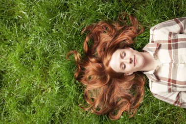 Teenage girl laying in grass clipart