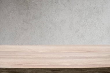 Modern bir grunge beton duvara karşı boş, ahşap bir masa. Kopyalamak için çok yer var