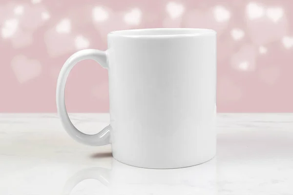 This Valentine inspired mock up features an 11 oz. white coffee cup resting on a white marble background. Soft white hearts glow romantically in the background.
