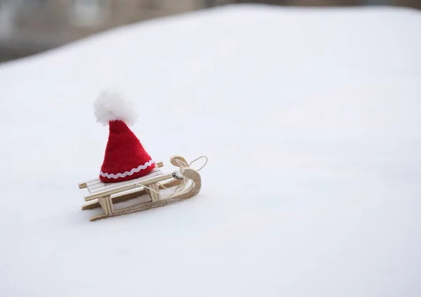 一顶木制雪橇上的圣诞老人帽子. — 图库照片