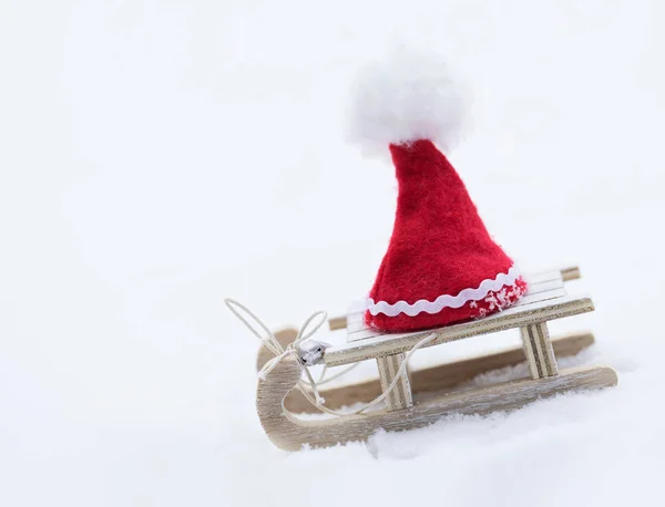 Kerstman hoed op een houten slee gemaakt. — Stockfoto