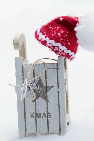 Kerstman hoed op een houten slee gemaakt. — Stockfoto