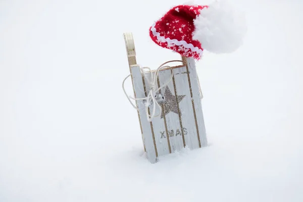 Santa Claus klobouk na dřevěné sáně vyrobené. — Stock fotografie