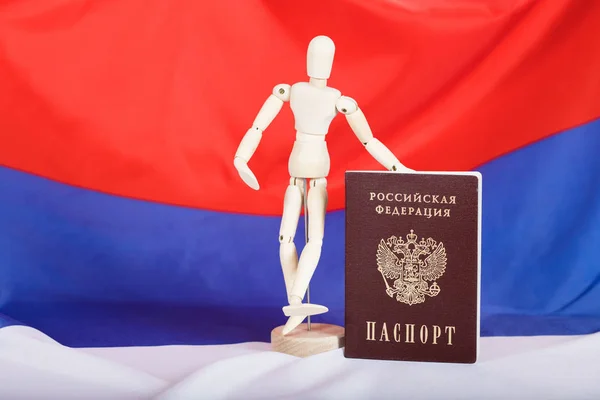 Russian pass and wooden dummy figurine on Russian flag.