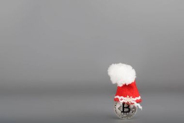 Bitcoin gri bir yüzey üzerinde Noel Baba şapkalı. 