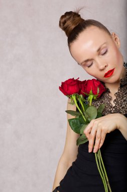 30 ila 40 yaşları arasında beyaz Bayan siyah bluz kırmızı ruj ve kırmızı gül ile poz. Portre 