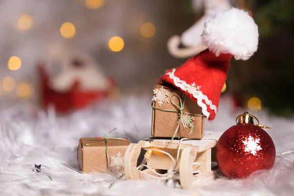 Zimní svátky pozadí: vánoční dárky na mini dřevěné sl — Stock fotografie