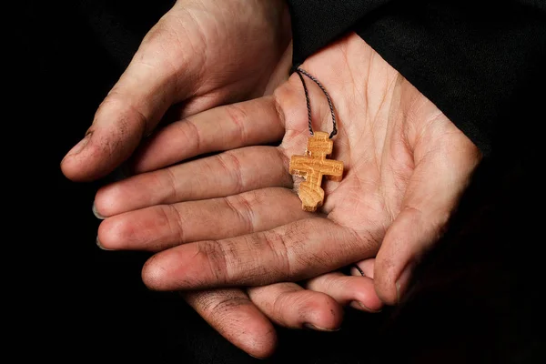 Houten handgemaakte kruis in de palm van de vrouw van een boer. — Stockfoto