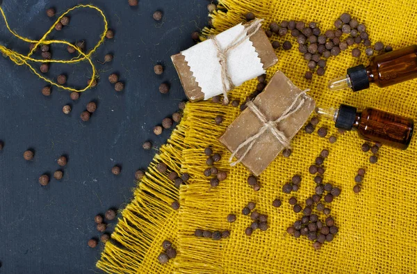 Cubeb pepper grains, soap, and cubeb essential oil on a wooden s — Stock Photo, Image