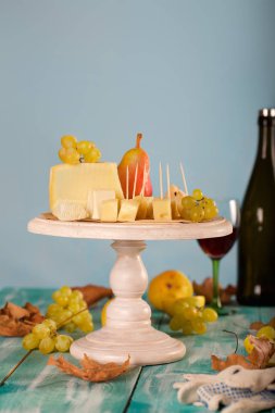 Peynir dilimleri, armut ve üzüm bir ahşap stand. 