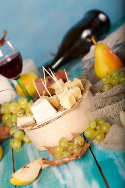 Peynir dilimleri, armut ve üzüm bir ahşap stand. 