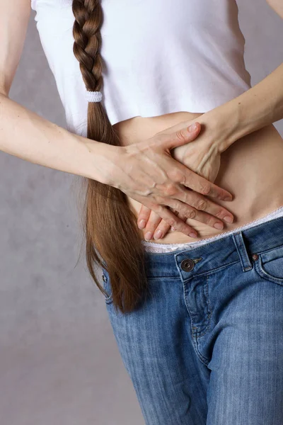 30岁到40岁的年轻女士穿着牛仔裤 肚子疼 — 图库照片