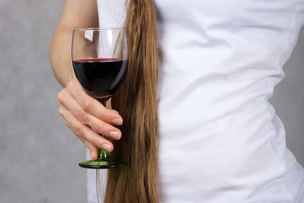 청바지를 입은 젊은 아가씨는 레드 와인 한 잔을 유지 합니다. 근접 촬영 — 스톡 사진
