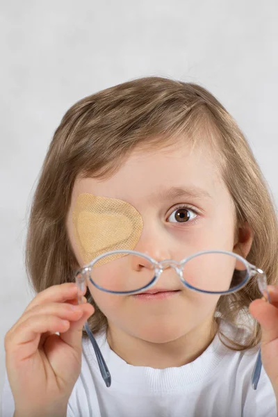 Garçon avec un oeil recouvert d'un collyre et avec des lunettes . — Photo