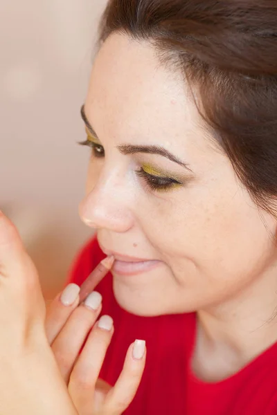 Young lady is applying make up on her face. Closeup — Stock Photo, Image