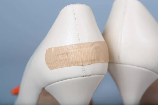 Adhesive bandage attached to summer high heels.