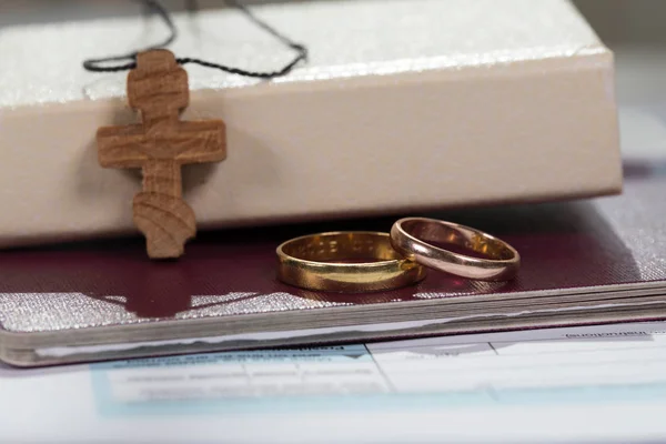 Anillos de matrimonio cerca de la Biblia con cruz de madera . — Foto de Stock