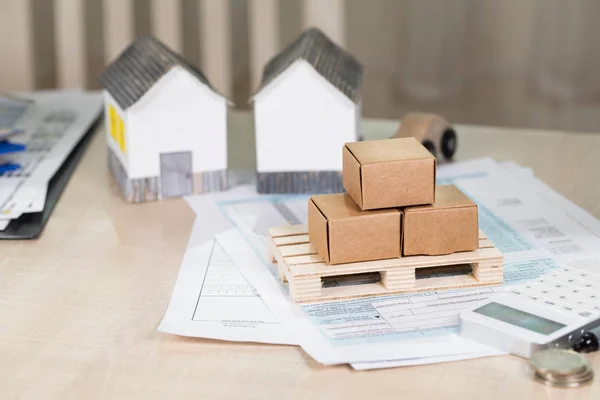 Palet ile karton kutularda önünde küçük kağıt evler. 