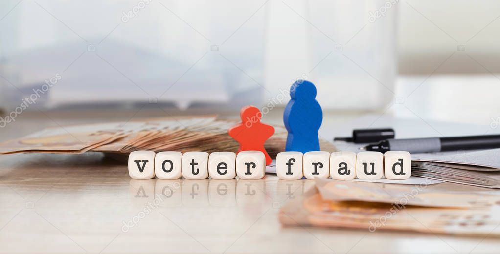 Word VOTER FRAUD composed of wooden letters. Closeup