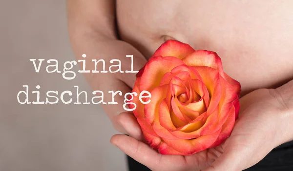 Palabras VAGINAL DISCHARGE. Mujer embarazada joven mantiene rosa natural — Foto de Stock