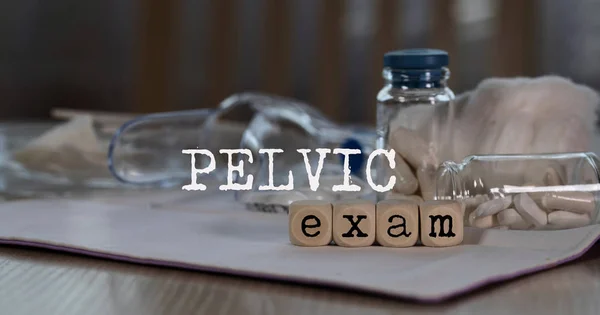 Words  PELVIC EXAM composed of wooden dices. Pills, documents an — Stock Photo, Image