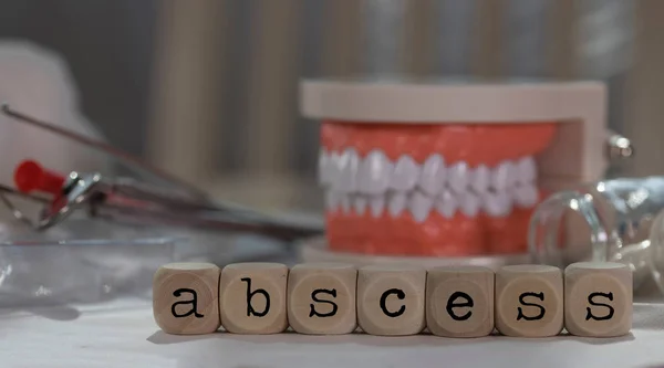 Word ABSCESS composed of wooden dices. Pills, documents, pen, hu Stock Photo