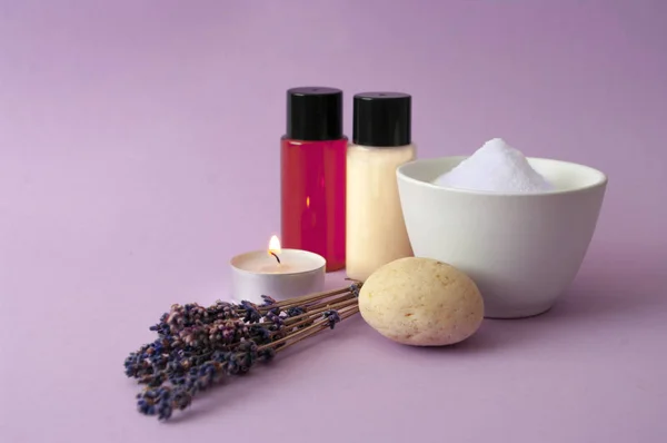 Lavender spa, salty scrub in ceramic bowl, shower gel, body cream, tea candle, stone. — Stock Photo, Image