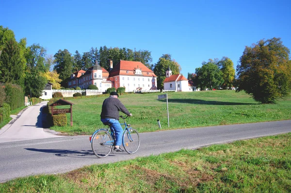 Grandfather rides bicycle in village, oldman, building of nursing home. Happy pensioner age. — 스톡 사진