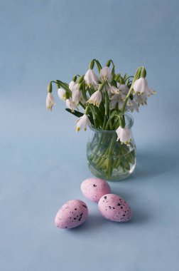 Yumurtalı Paskalya tebrik kartı ve mavi arka planda bahar kar tanesi çiçekleri. Ekran Duvar Kağıdı.