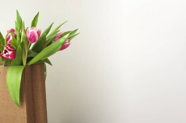 Kırmızı lale buketli pankart, 8 Mart, kadınlar günü, anneler günü, kağıt torba. Çiçeklerle romantik bir fon. Bahar satışları