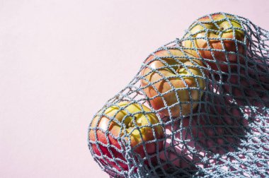 Pembe arka planda eko örülmüş taze elmalar sağlıklı meyveler, çevre dostu, sıfır atık