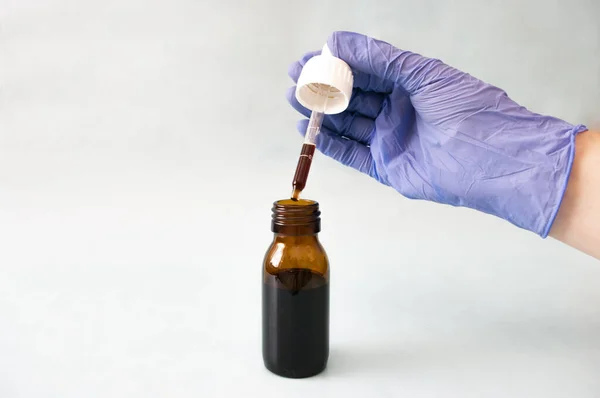El mavisi koruyucu eldiven cam şişede damlatıcı, koronavirüs ilacı, sağlık koruyucusu, şurup, aşı.