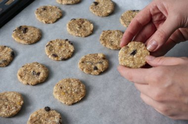 Taze yulaflı kurabiyeler, el ele tutuşup pişirme işlemi. Vejetaryen yemekleri, tatlılar. Ev yapımı Raw