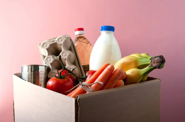 Bağış kutusu, yiyecek, temas kurulamayan teslimat, market. İnternetten alışveriş siparişi. Pembe arkaplanda.