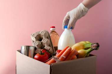 Market ve yiyeceklerle dolu bir bağış kutusu. Yumurta, havuç, süt, domates, konserve yiyecek, muz, yağ. Tecrit süresi karantina, temas yok. Coronavirüs