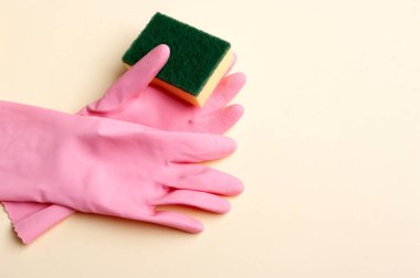 Pembe lastik eldivenler ve sünger, temizlik afişi kopyalama alanı metni.