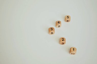 Beyaz arka planda farklı numaralara sahip beş tahta zar. Kapatın. Boşluğu kopyala.