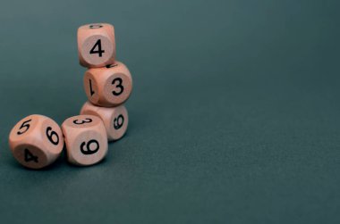 Koyu yeşil arka planda farklı numaralara sahip beş tahta zar, kaybet. Boşluğu kopyala.