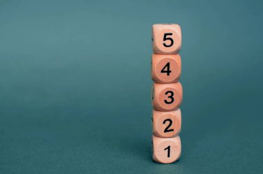 Koyu yeşil arka planda farklı numaralara sahip beş tahta zar, kaybet. Boşluğu kopyala.