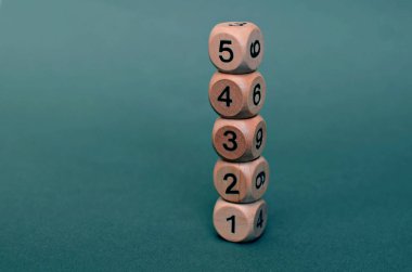 Koyu yeşil arka planda farklı numaralara sahip beş tahta zar, kaybet. Boşluğu kopyala.