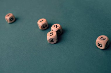 Koyu yeşil arka planda farklı numaralara sahip beş tahta zar, kaybet. Boşluğu kopyala.