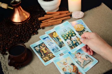 Tarot kartları ve fal bakımı, branda peçete arka planı, kahve fincanı ve kahve çekirdekleri.